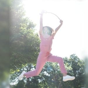 Woman in pink scrubs jumping in the air