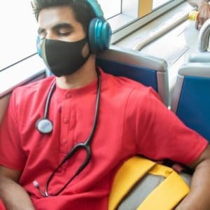 masked nurse sitting on a bus