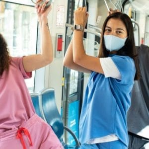 three masked nurses standing on the subway